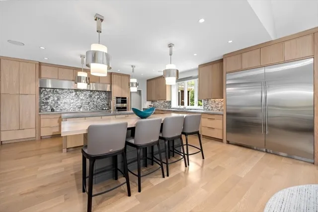 a kitchen with a dining table chairs and refrigerator