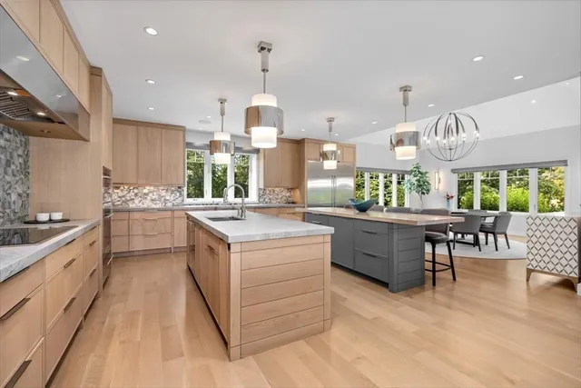 a kitchen with a sink stove cabinets and wooden floor