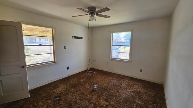 a view of empty room with ceiling fan