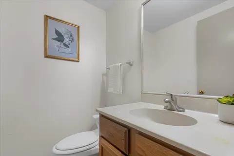 a bathroom with a granite countertop toilet sink and mirror