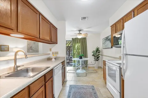 a kitchen with a refrigerator sink and white cabinets