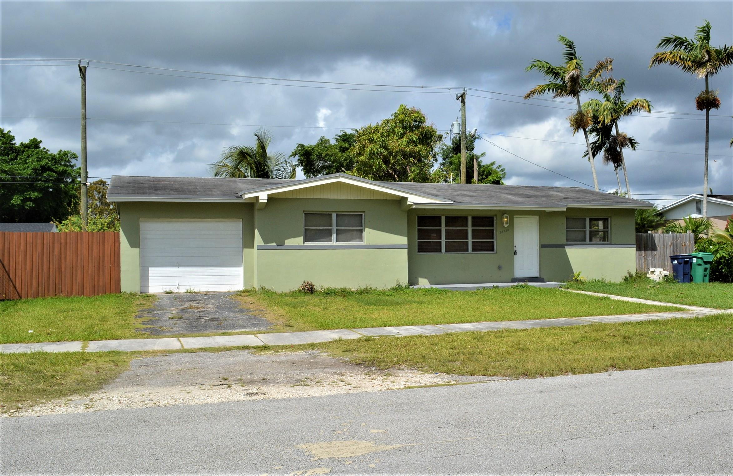28520 Southwest 146th Avenue Homestead, FL 33033 - Photo 1 of 23 a front view of a house with a garden and trees