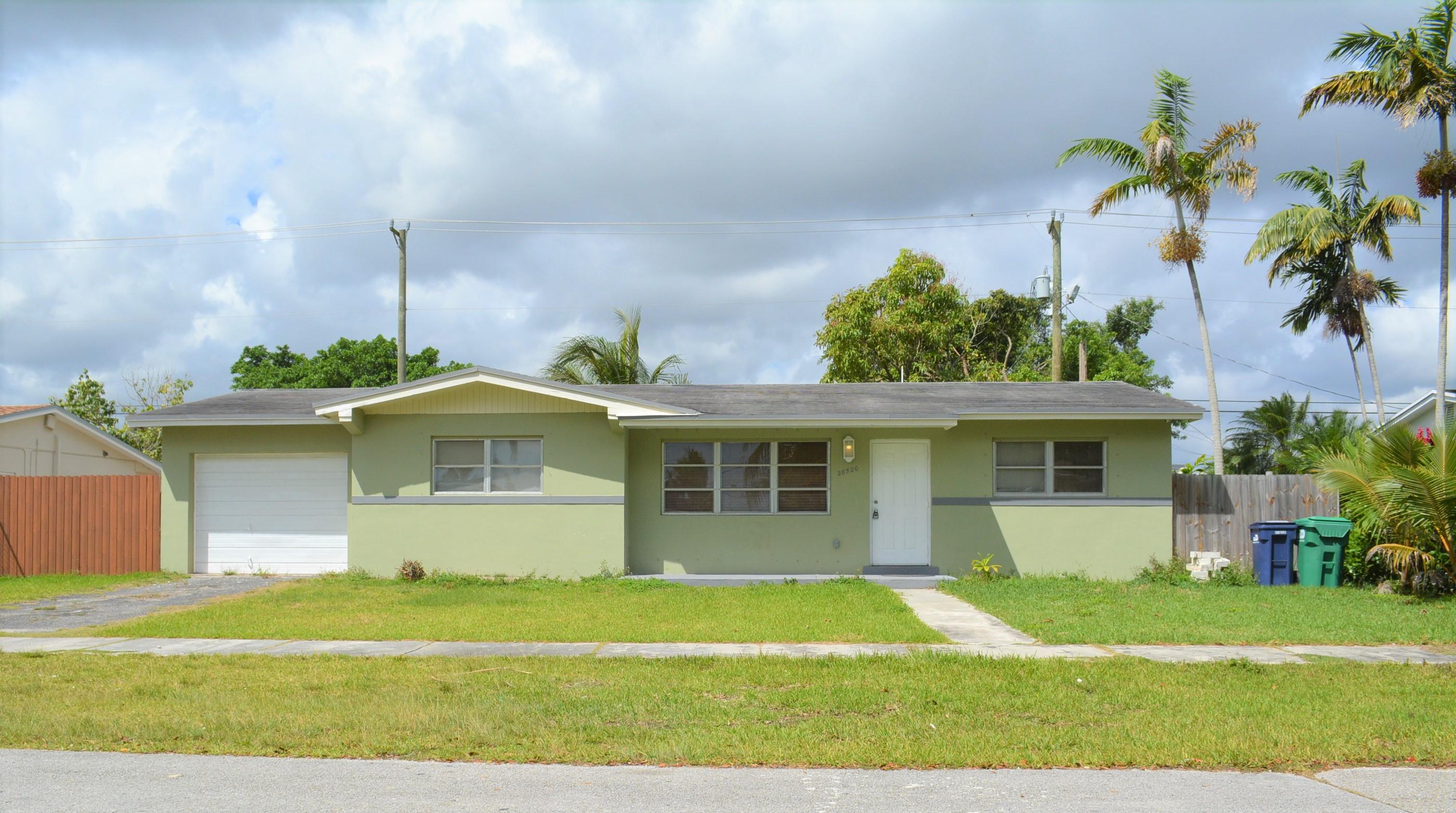28520 Southwest 146th Avenue Homestead, FL 33033 - Photo 2 of 23 a front view of a house with a garden and plants
