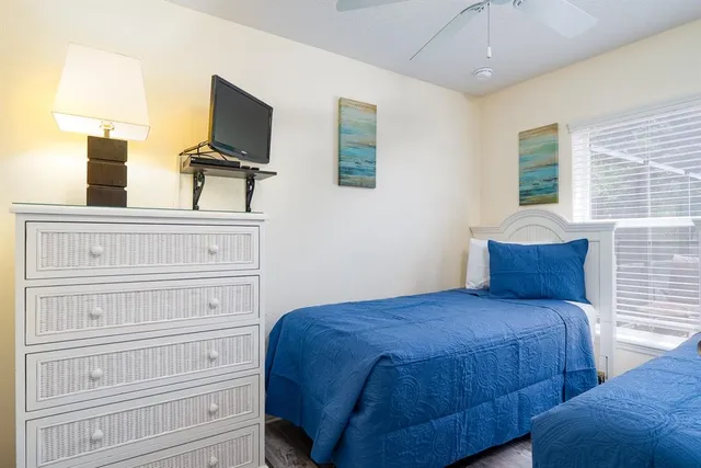 a bedroom with a large bed and a flat tv screen on dresser