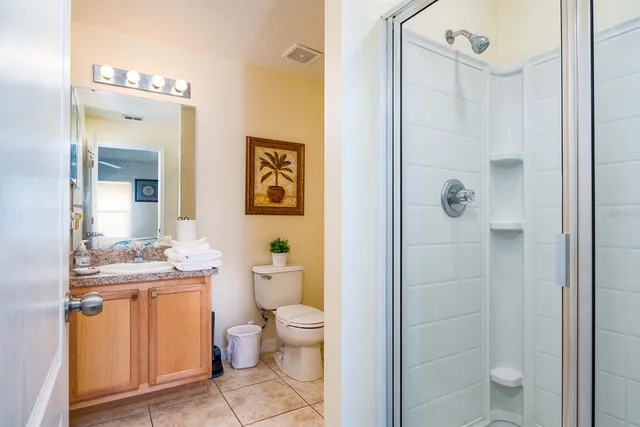 a bathroom with a granite countertop sink toilet and shower