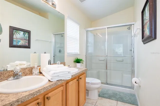 a bathroom with a granite countertop sink toilet a mirror and shower