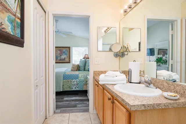 a en suite bathroom with a granite countertop sink and a mirror