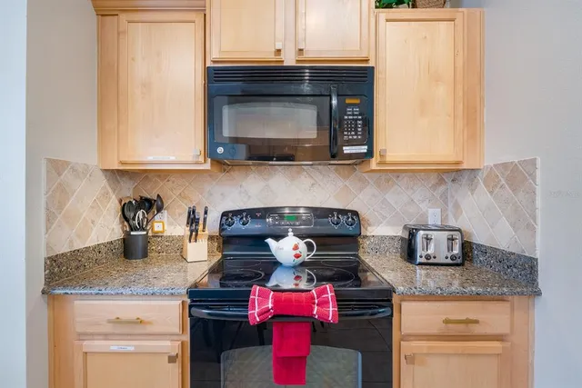 a kitchen with stainless steel appliances granite countertop a stove and a microwave