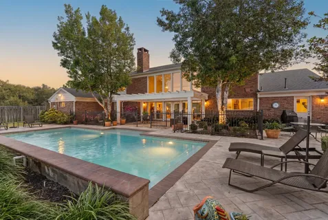 a view of a house with swimming pool and sitting area