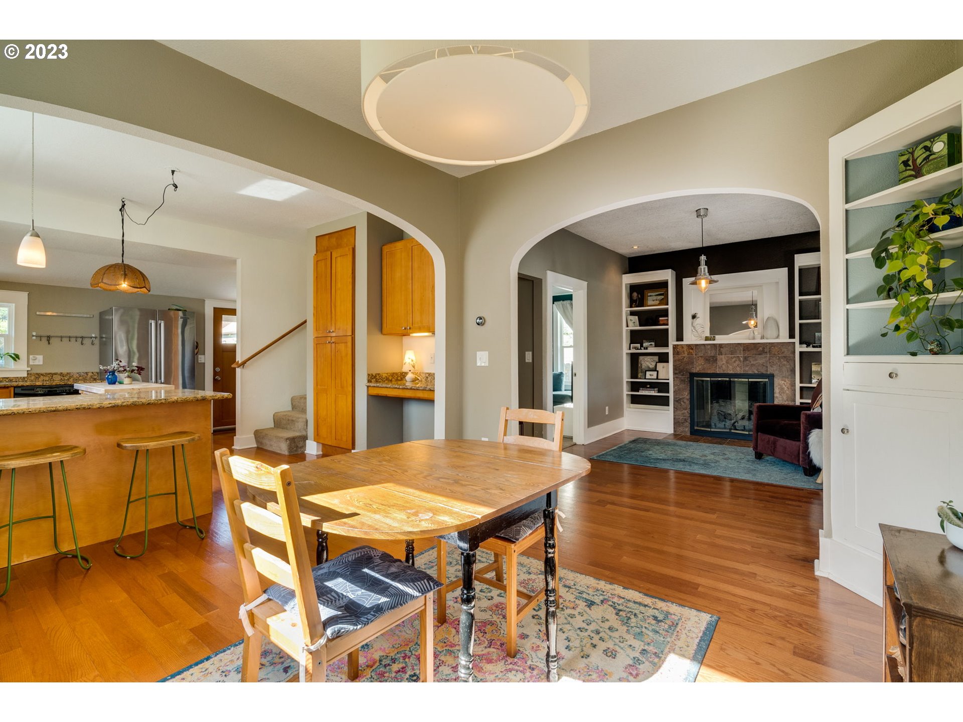 4504 Northeast Alberta Court Portland, OR 97218 - Photo 13 of 37 a living room with furniture a fireplace and a kitchen view