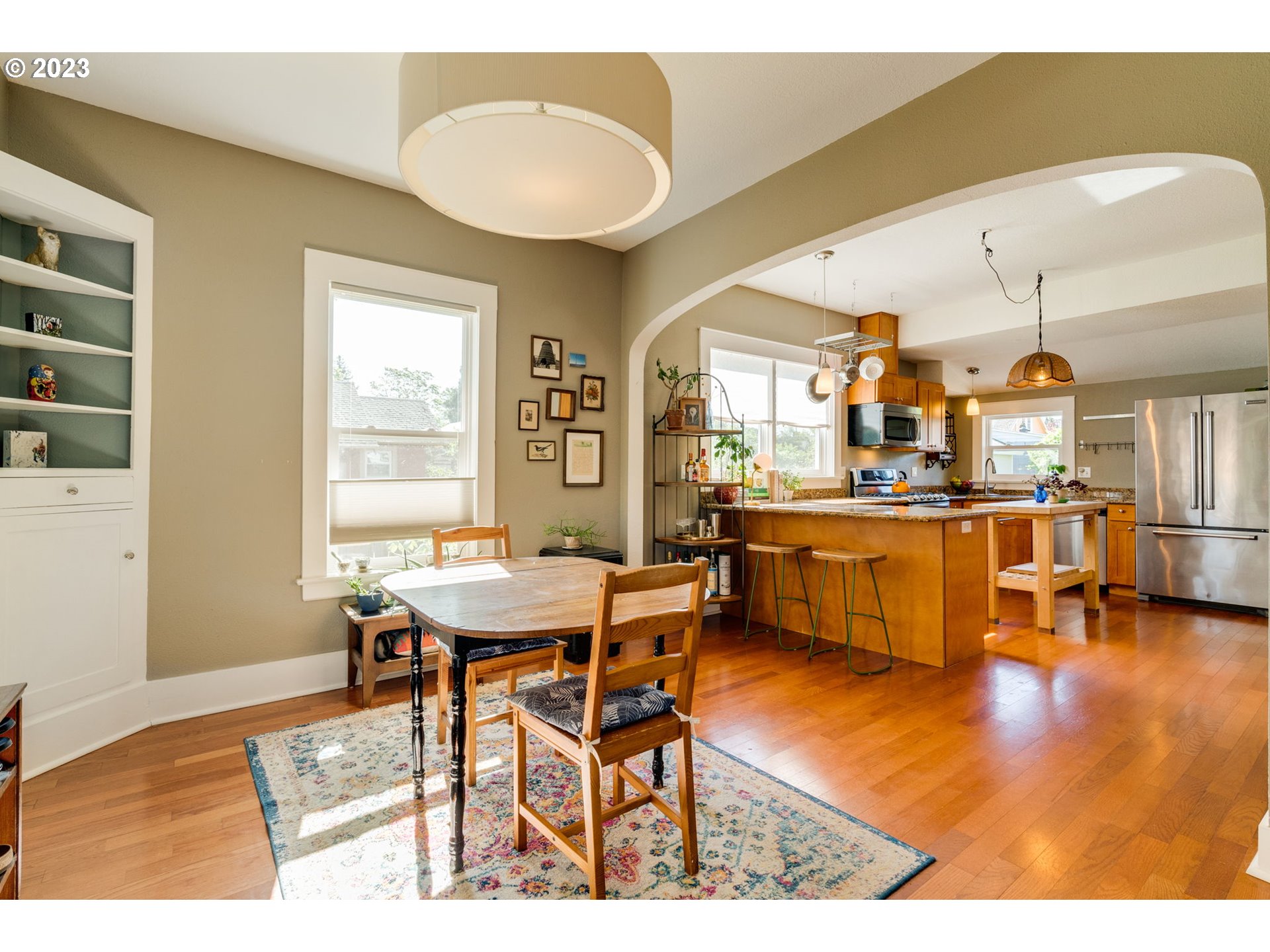 4504 Northeast Alberta Court Portland, OR 97218 - Photo 6 of 37 a dining hall with stainless steel appliances kitchen island granite countertop a dining table and chairs with wooden floor