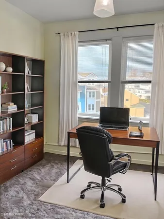 a view of a workspace with furniture and a window
