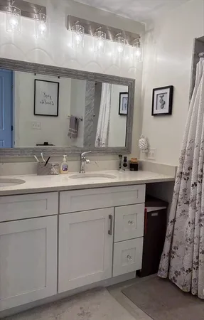 a bathroom with a double vanity sink and a mirror