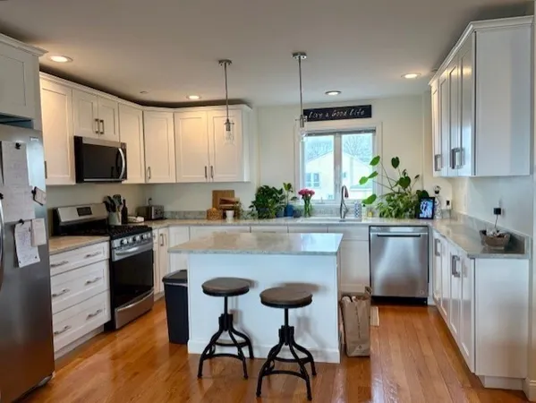 a kitchen with white cabinets and stainless steel appliances