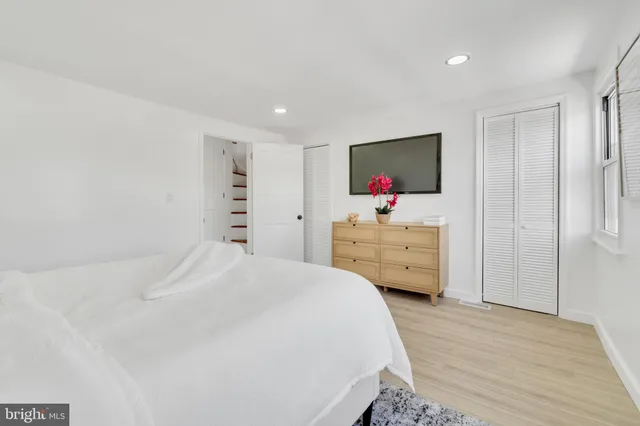 a bedroom with a bed and a flat tv screen on dresser