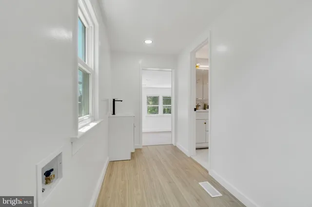 a view of a hallway with wooden floor and staircase