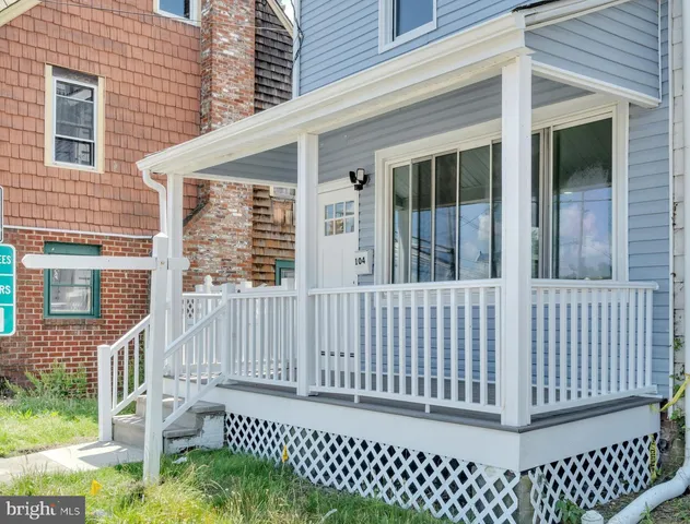 a view of a house with a small yard and wooden floor and fence