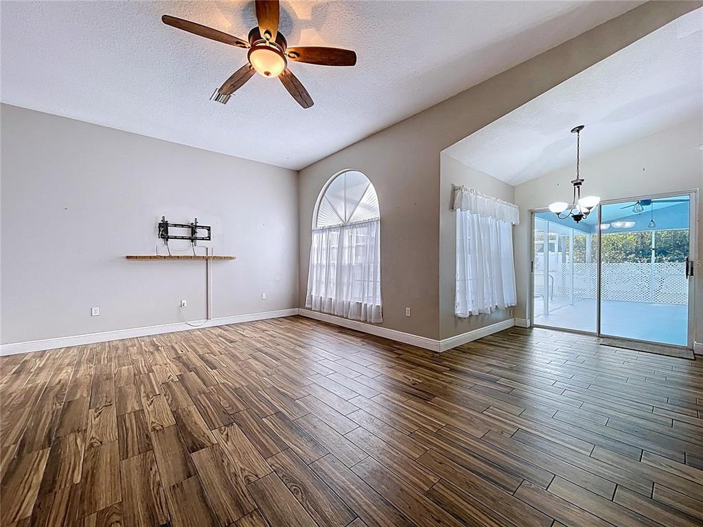 18812 Bascomb Lane Hudson, FL 34667 - Photo 21 of 57 a view of an empty room with wooden floor ceiling fan