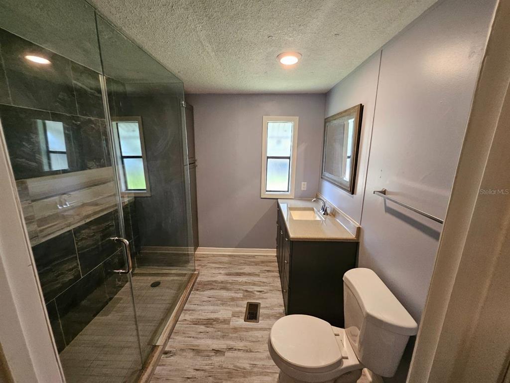 6445 Belle Terre Road New Port Richey, FL 34653 - Photo 12 of 16 a bathroom with a toilet a sink and mirror