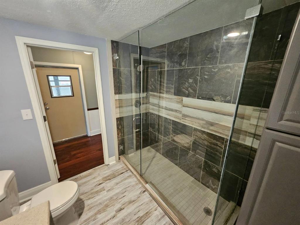 6445 Belle Terre Road New Port Richey, FL 34653 - Photo 13 of 16 a bathroom with a shower and toilet