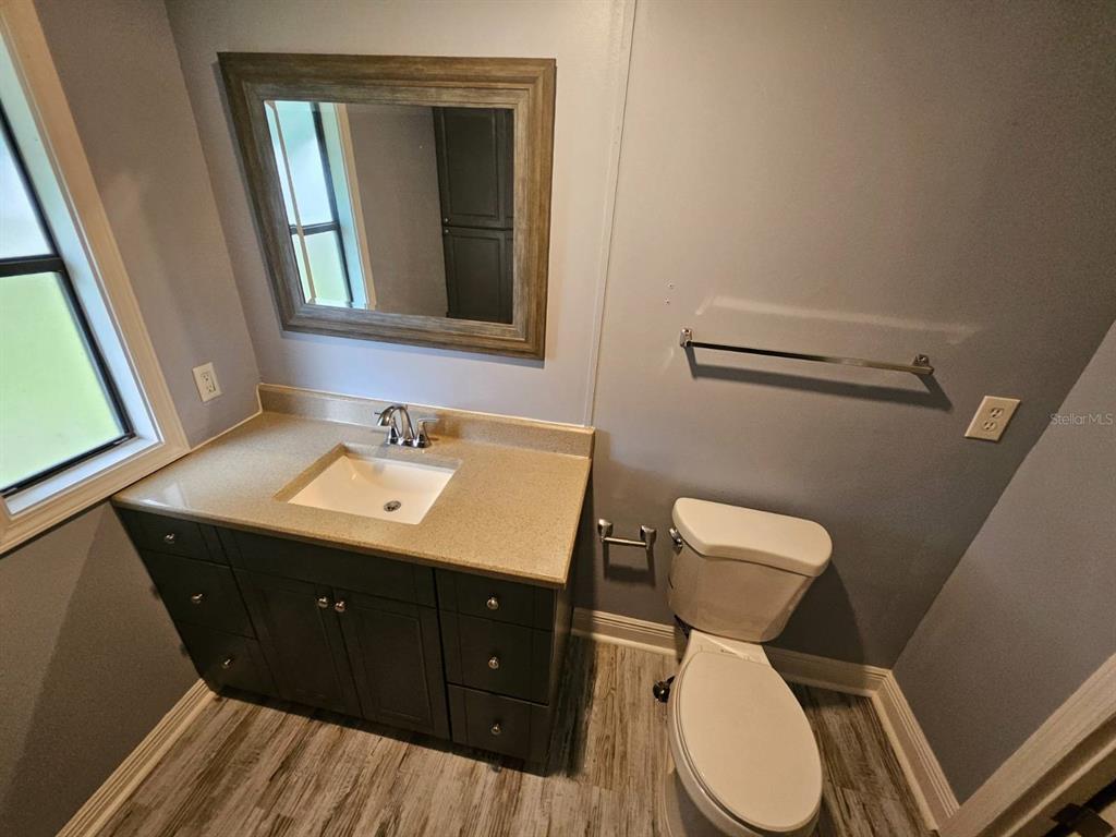6445 Belle Terre Road New Port Richey, FL 34653 - Photo 15 of 16 a bathroom with a toilet sink and mirror
