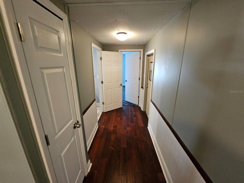 6445 Belle Terre Road New Port Richey, FL 34653 - Photo 7 of 16 a view of a hallway with wooden floor and staircase