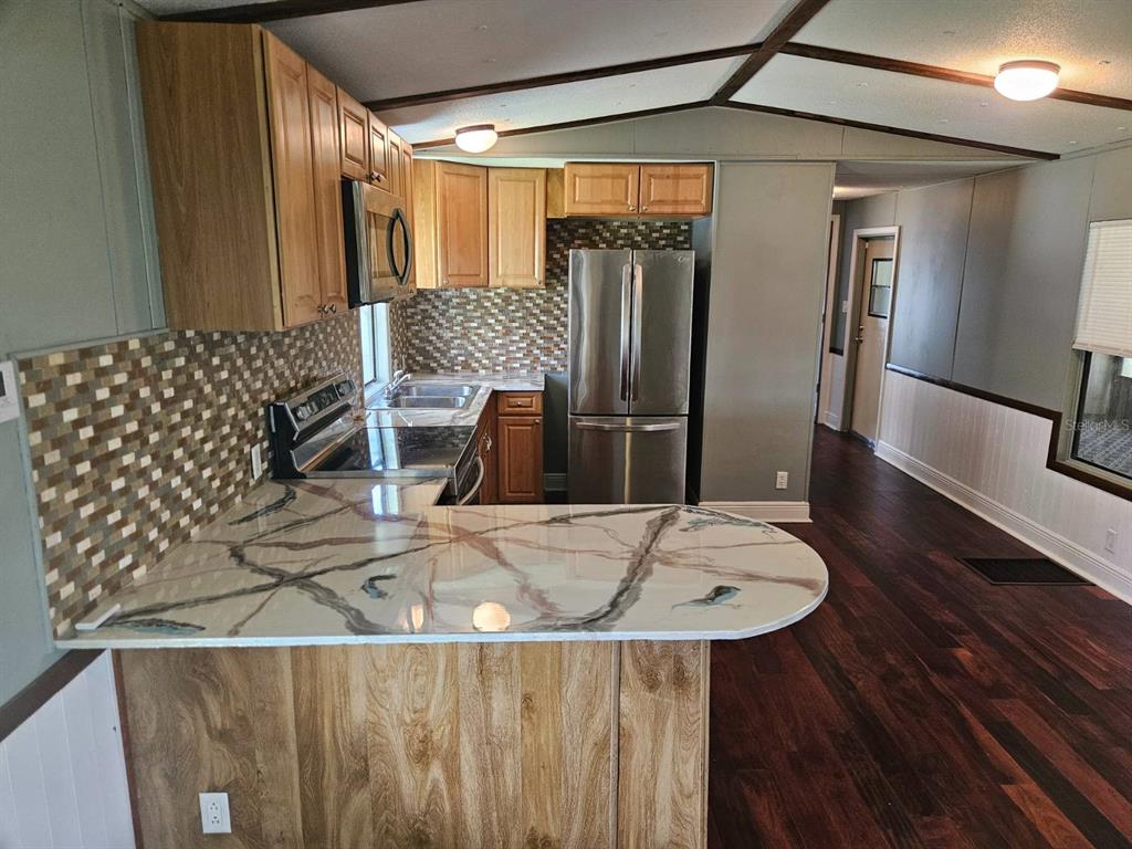 6445 Belle Terre Road New Port Richey, FL 34653 - Photo 10 of 16 a kitchen with a table and chairs