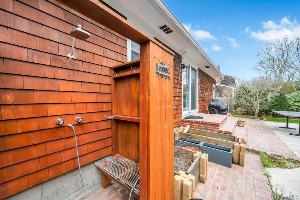 8 Lovell Road Hampton Bays, NY 11946 - Photo 5 of 20 a backyard of a house with barbeque oven table and chairs