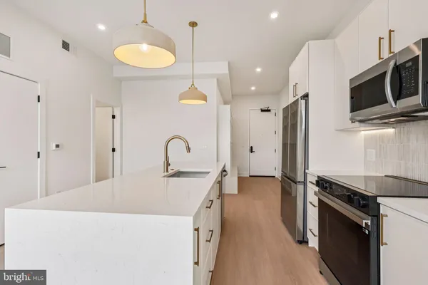 a kitchen with stainless steel appliances a stove microwave and sink