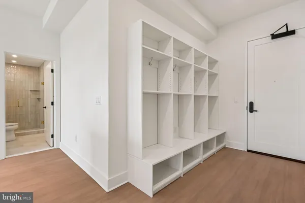 a view of a hallway with wooden floor and closet