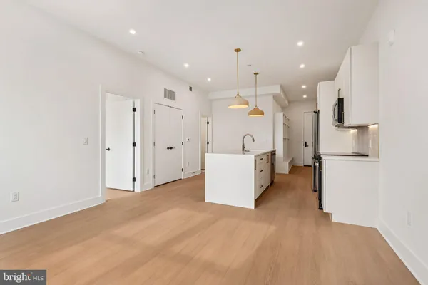 a view of a kitchen with refrigerator and white cabinets