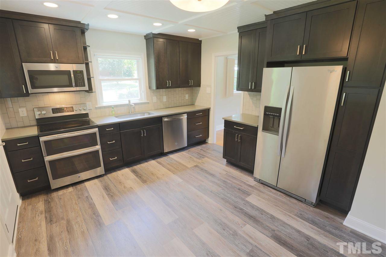 3501 Cranston Road Garner, NC 27529 - Photo 9 of 18 a large kitchen with stainless steel appliances wooden cabinets a stove a sink and a refrigerator