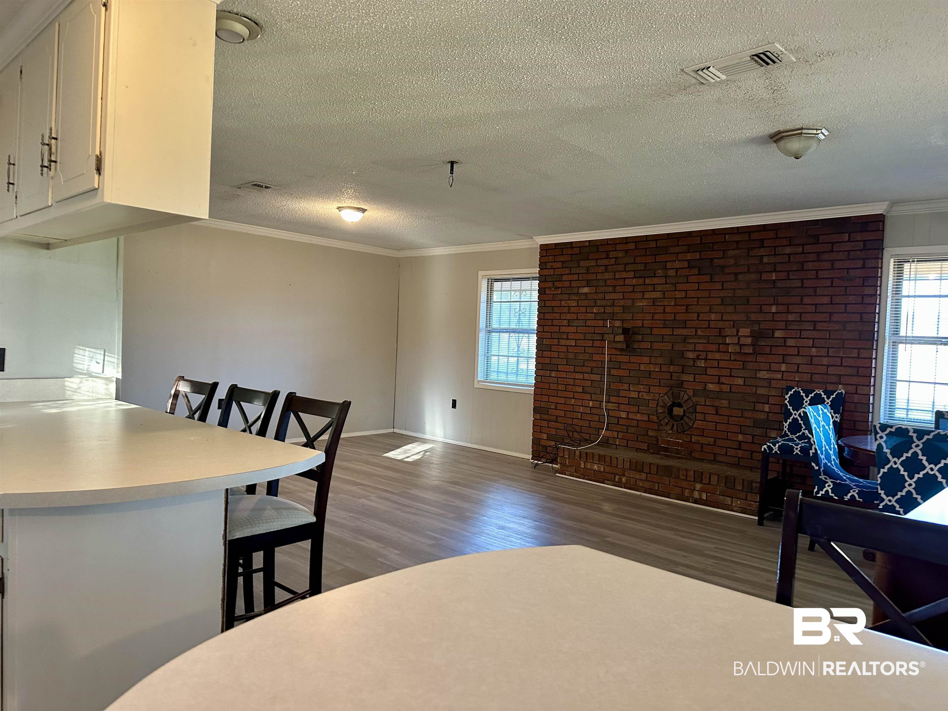3451 Kirkland Road Brewton, AL 36426 - Photo 7 of 17 Dining room with a textured ceiling, dark hardwood / wood-style floors, and crown molding