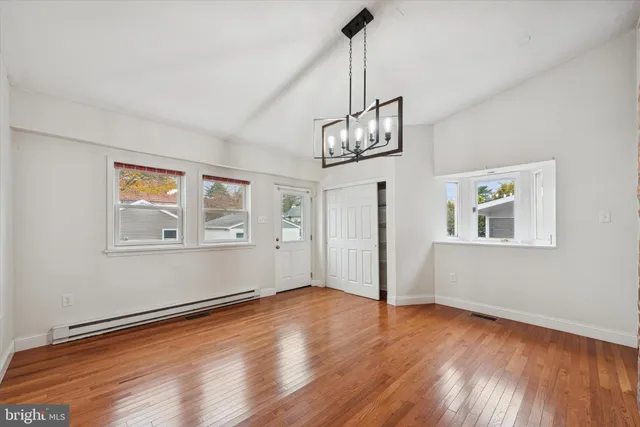 a view of empty room with wooden floor and window