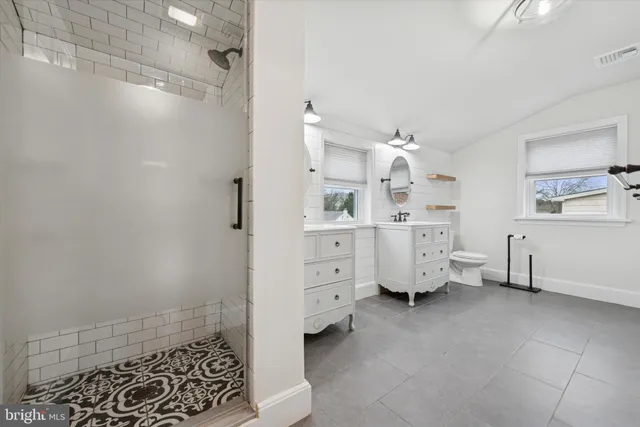 a spacious bathroom with a double vanity sink and mirror