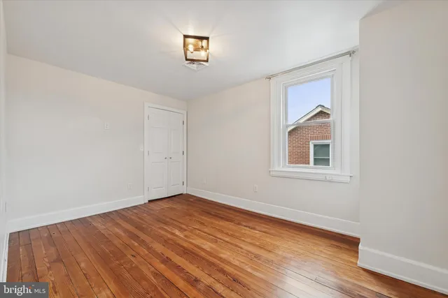 a view of a room with wooden floor and a window