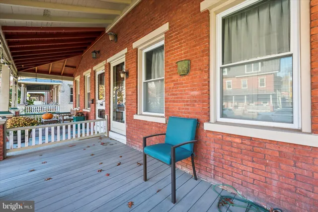 a porch area with wooden floor and outdoor seating