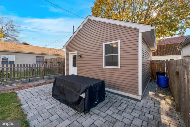 a view of backyard with barbeque grill and wooden fence