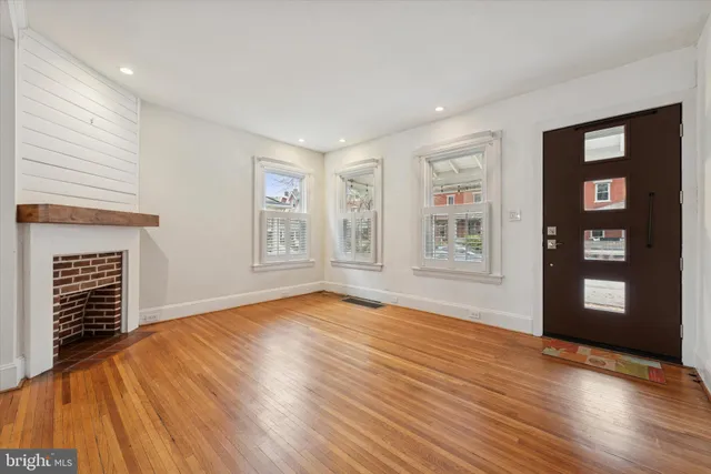 a view of an empty room with window and wooden floor
