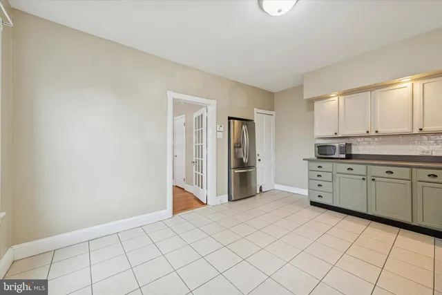 a kitchen with granite countertop white cabinets and refrigerator