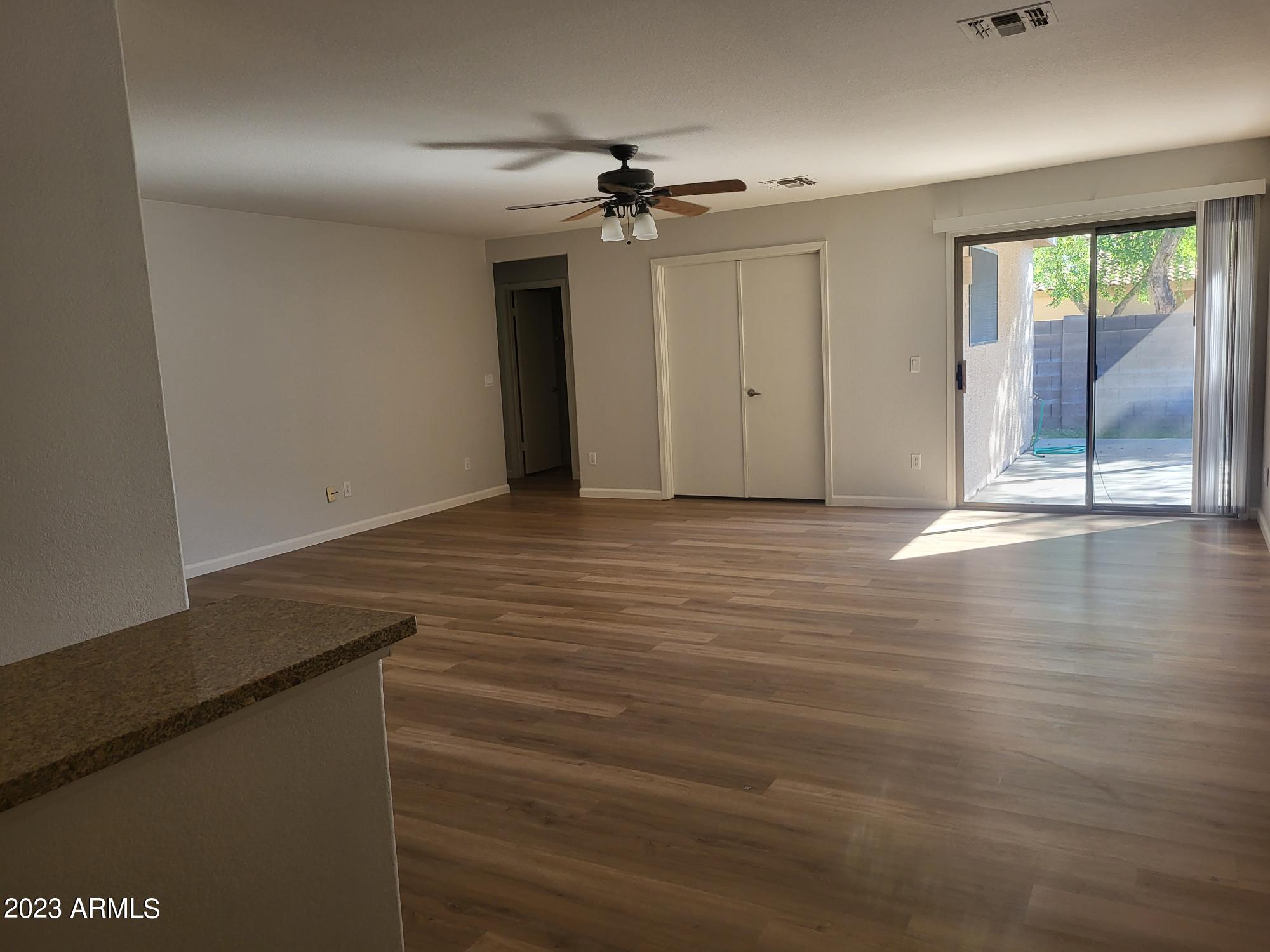 18611 North 22nd Street, Unit 9 Phoenix, AZ 85024 - Photo 2 of 18 an empty room with wooden floor and a ceiling fan