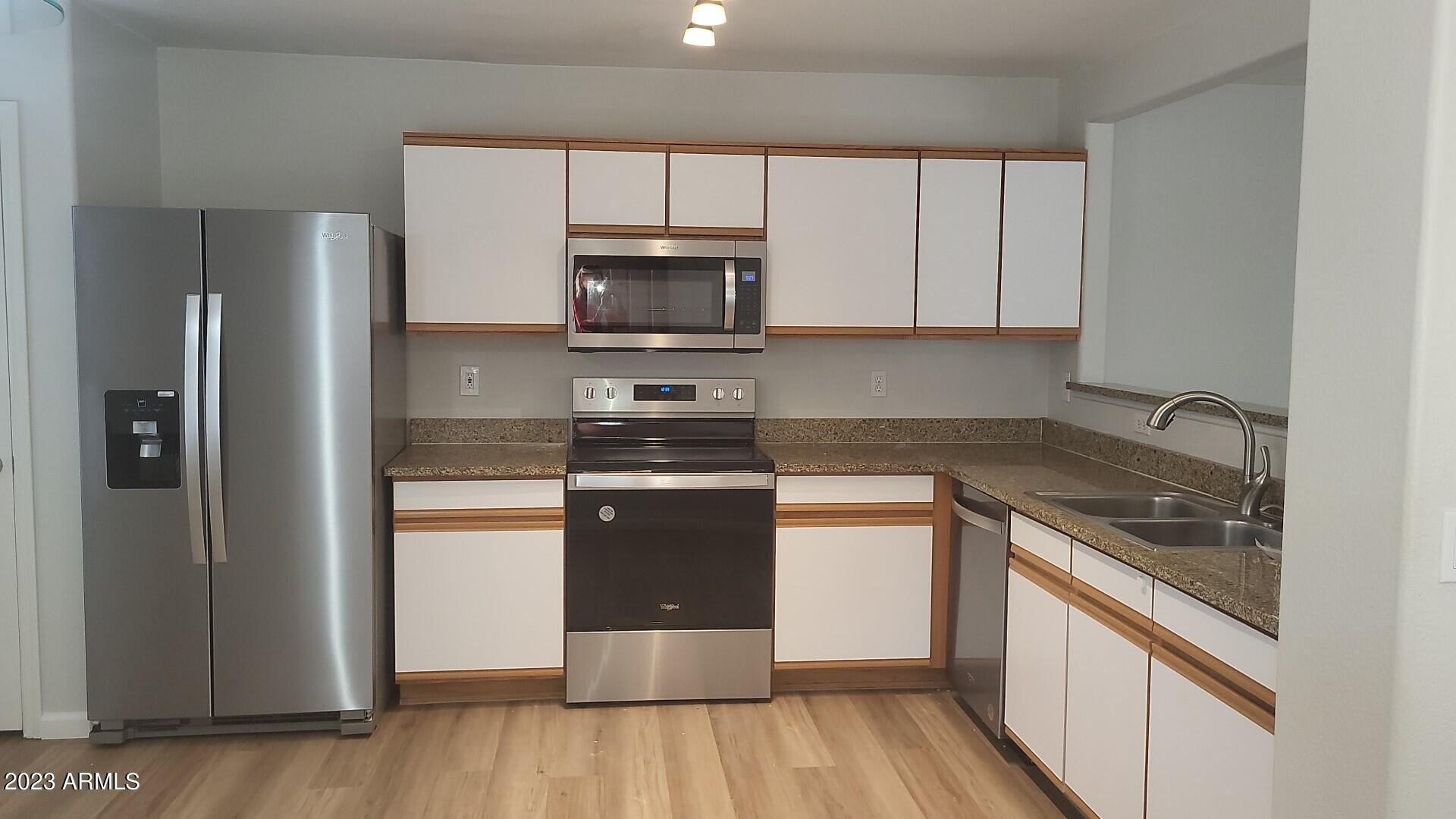 18611 North 22nd Street, Unit 9 Phoenix, AZ 85024 - Photo 5 of 18 a kitchen with stainless steel appliances granite countertop a stove a refrigerator and a microwave