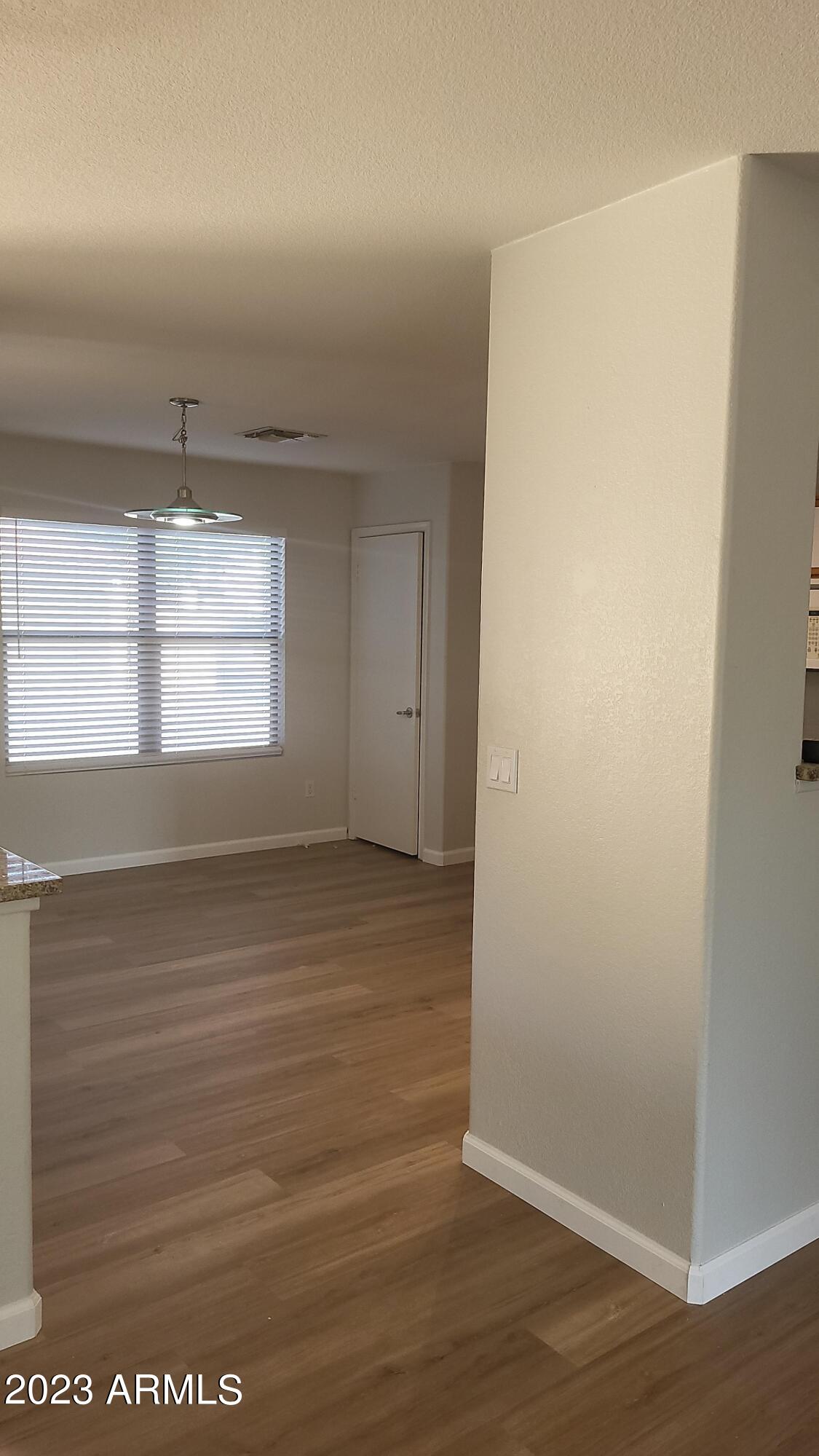18611 North 22nd Street, Unit 9 Phoenix, AZ 85024 - Photo 8 of 18 a view of an empty room with wooden floor and window