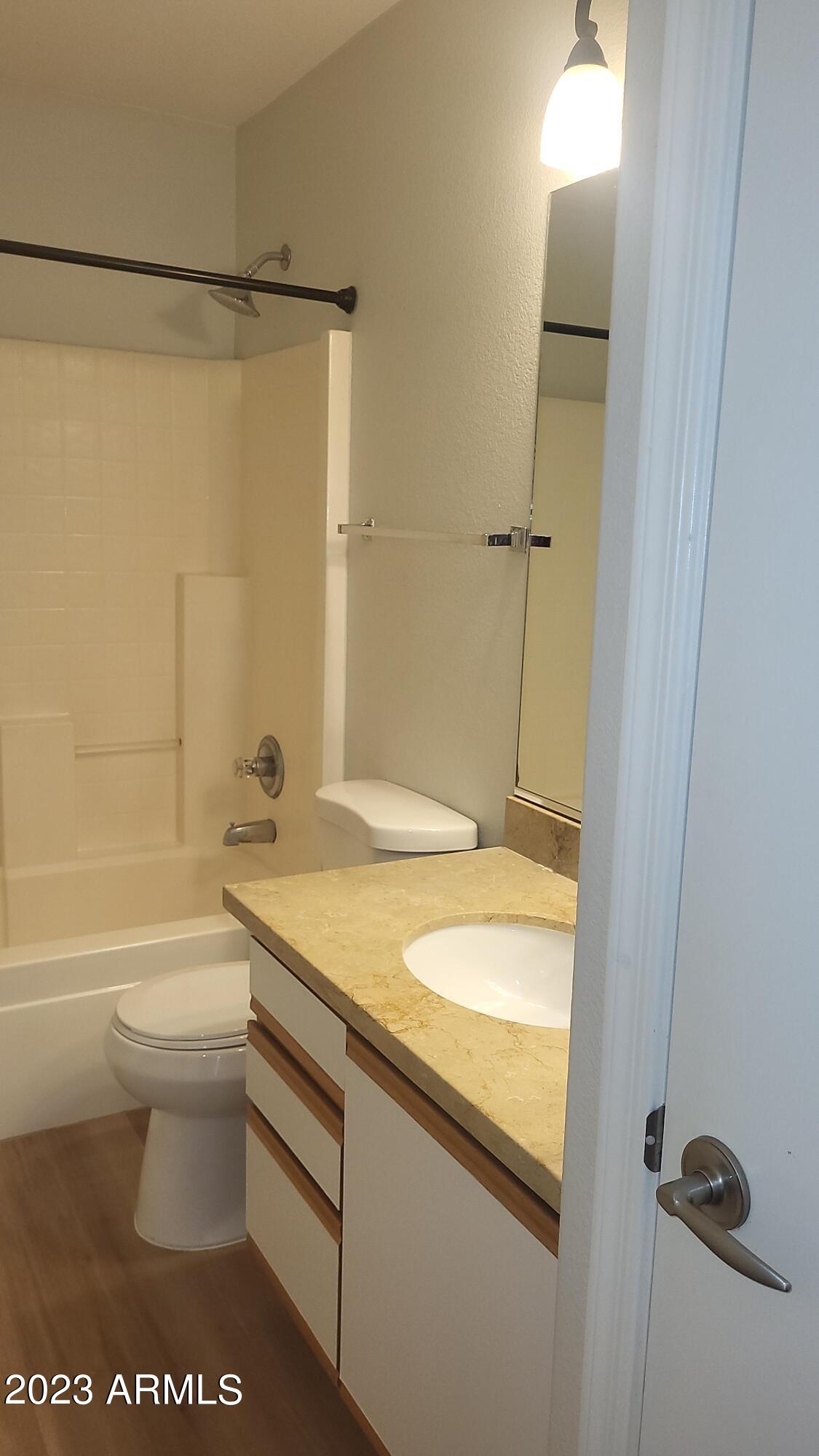18611 North 22nd Street, Unit 9 Phoenix, AZ 85024 - Photo 9 of 18 a bathroom with a granite countertop sink toilet and shower