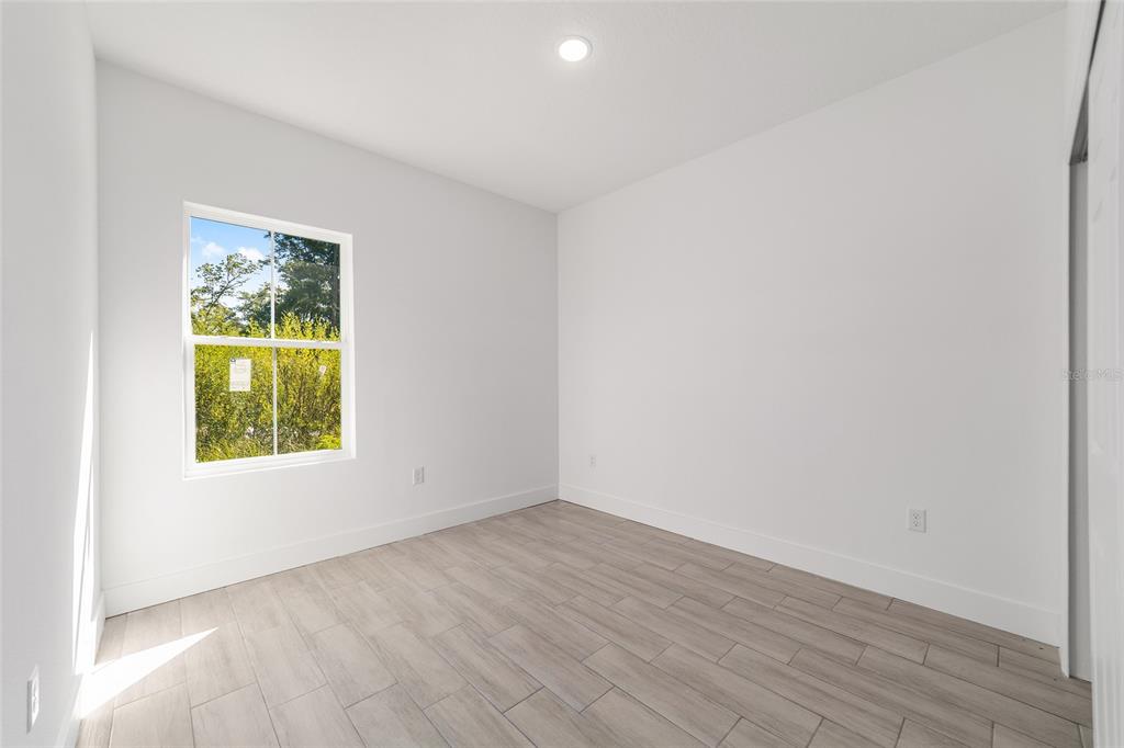 15431 Southwest 41st Street Road Ocala, FL 34481 - Photo 27 of 44 an empty room with wooden floor and windows