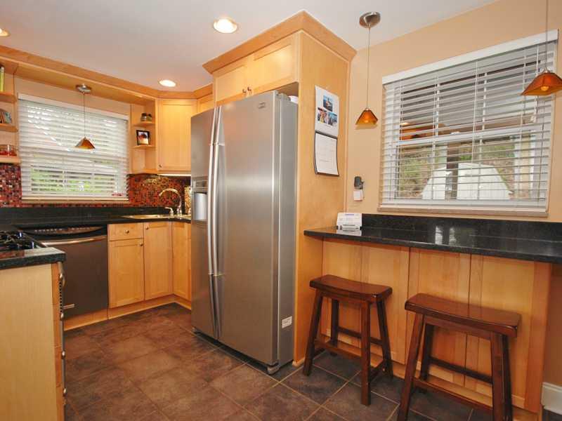 146 Orchard Spring Road Pittsburgh, PA 15220 - Photo 10 of 25 Kitchen. The breakfast bar is accented with two amber-toned pendant lamps. The window overlooks the screened porch. The side-by-side stainless refrigerator is also included in the sale.