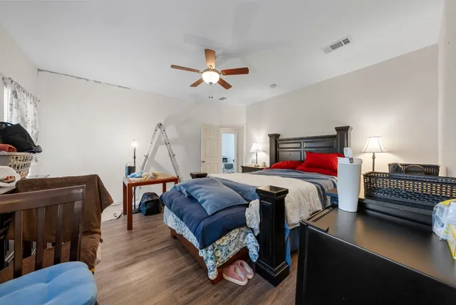 a bedroom with a bed and wooden floor