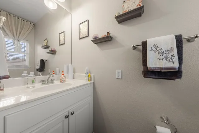 a bathroom with a sink mirror and vanity