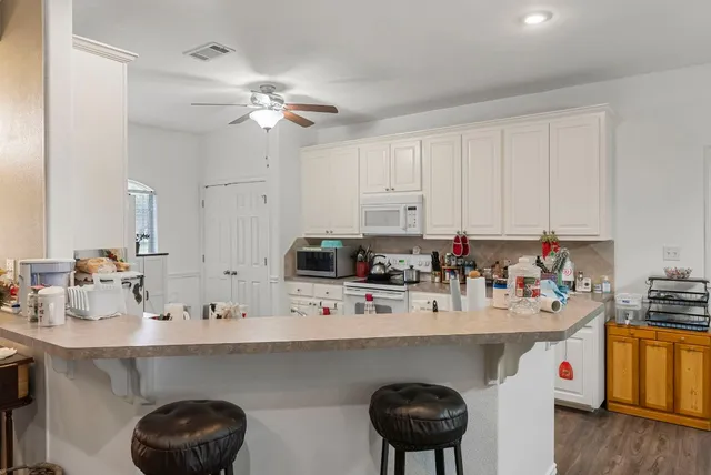 a kitchen with stainless steel appliances a sink a table and chairs