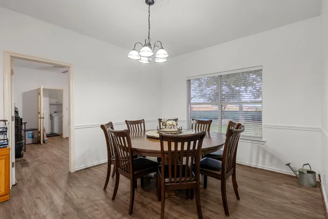 a view of a dining room with furniture a chandelier and wooden floor